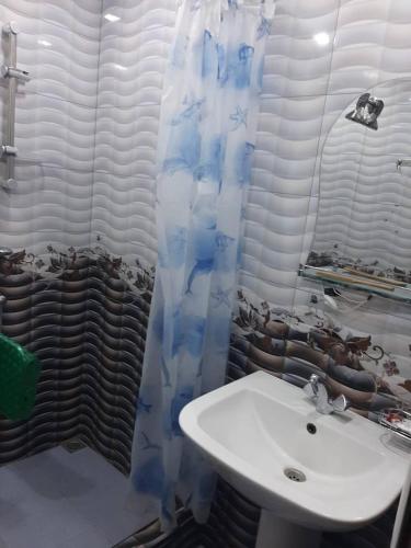 a bathroom with a sink and a shower curtain at Guest house in Jermuk