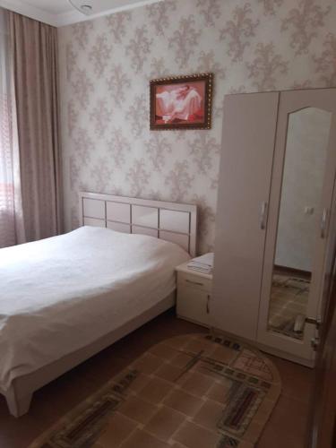 a bedroom with a bed and a dresser and a mirror at Guest house in Jermuk