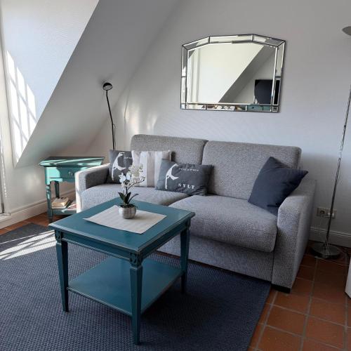 a living room with a couch and a table at Kastanienhüs Apartment in Westerland
