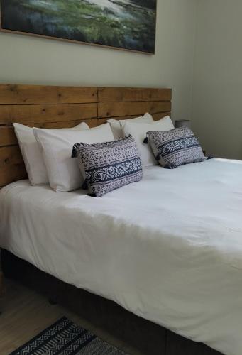 a large white bed with pillows on top of it at The Loft in Mtunzini
