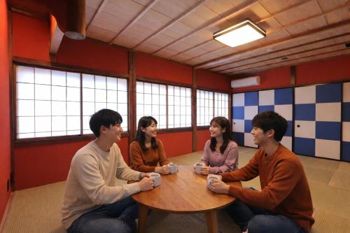 four people sitting around a table playing a video game at 龍助25ANNEX Ryusuke25ANNEX in Komatsu