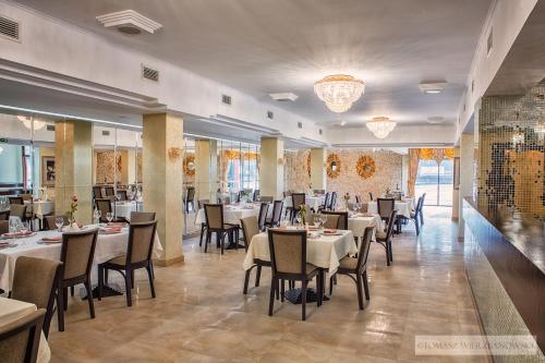 a restaurant with tables and chairs in a room at Hotel Lord Krosno in Krosno