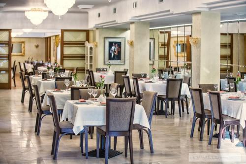 a dining room with white tables and chairs at Hotel Lord Krosno in Krosno
