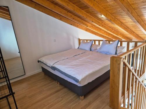 a bed with blue pillows in a room at Casa do Barco in Odiáxere