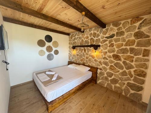 a bed in a room with a stone wall at Medo in Ulcinj