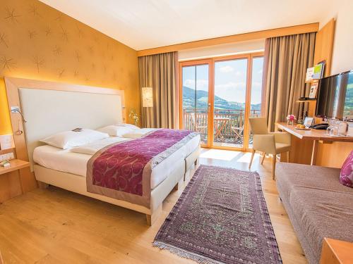a hotel room with a bed and a desk and a window at RETTER Bio-Natur-Resort in Pöllauberg