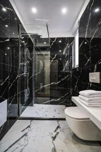 a black bathroom with a shower and a toilet at Hotel Capital Inn Tirana by Arta in Tirana