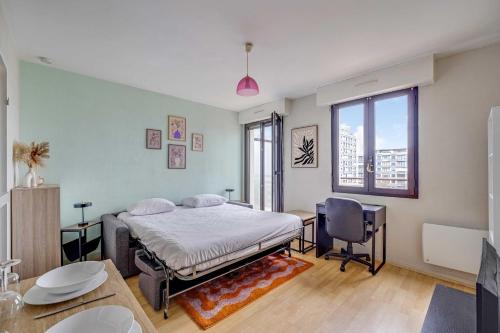 a bedroom with a bed and a desk and a chair at Spacious Studio 2P - Near La Défense in Courbevoie