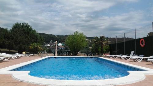 a large swimming pool with chairs at Hostal Los Pinares in Lloret de Mar