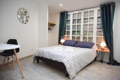 a bedroom with a bed and a window at Logement Poséidon in Boulogne-sur-Mer