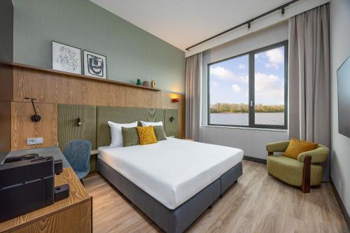 a hotel room with a bed and a tv at Postillion Hotel Breda Biesbosch in Raamsdonksveer