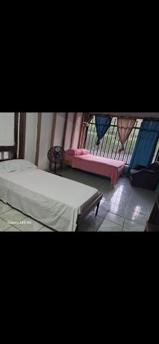 a bedroom with a bed and a window with a fence at Casa,del vozque in Manzanillo