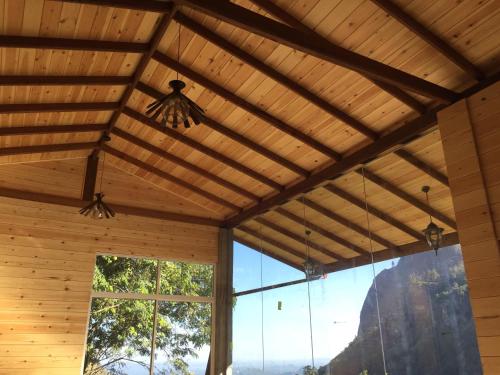 a room with a wooden ceiling and a large window at Country Homes in Ella