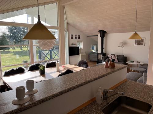 a kitchen with a counter top and a living room at Lækkert sommerhus i gåafstand til by og strand in Bøtø By