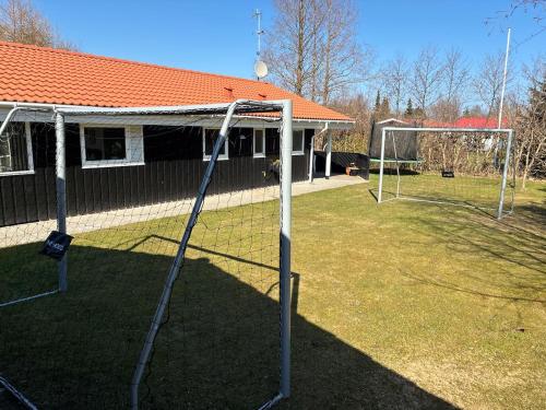 a soccer goal in a yard with a building at Lækkert sommerhus i gåafstand til by og strand in Bøtø By