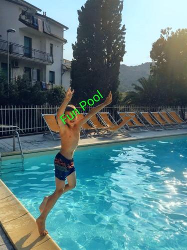a young man jumping into a swimming pool at Residence Oleandro in Pietra Ligure