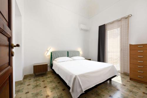 a bedroom with a white bed and a window at Sinedda Sole in San Vito lo Capo