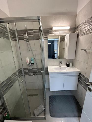 a bathroom with a shower and a sink at Pool View Studio Apartment Caesar Resort & Spa in Dherinia