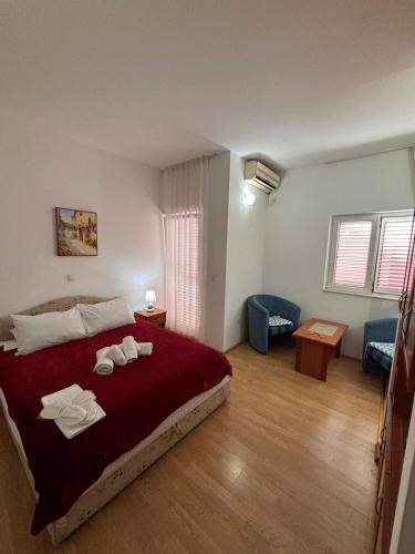 a bedroom with a large bed with towels on it at Guest House Garden in Budva