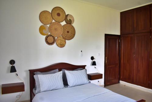 a bedroom with a bed with plates on the wall at Villa les 3 oisillons in Kribi