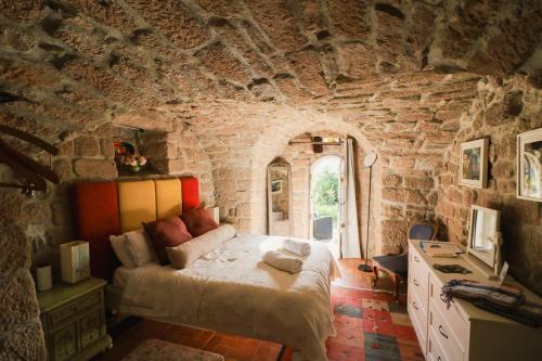 a bedroom with a bed in a stone wall at Idyllic French farmhouse in Les Assions