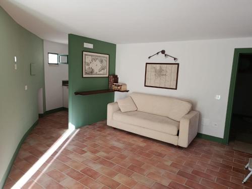 a living room with a couch and green and white walls at GuestHouse Tana del Riccio Todi in Todi