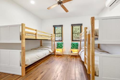 two bunk beds in a room with a ceiling fan at Bright Vista with Studio in Bright