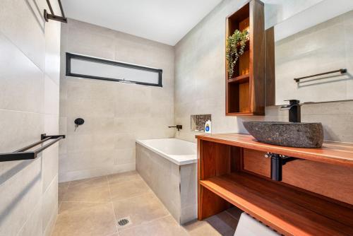 a bathroom with a sink and a bath tub at Bright Vista with Studio in Bright