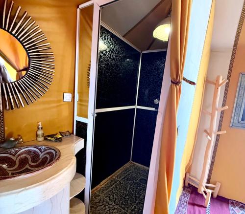 a bathroom with a shower with a sink and a mirror at Merzouga Luxury Tents & Activities in Merzouga