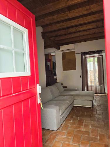 a living room with a couch and a red door at Casa Pedra da Foz in Odeceixe