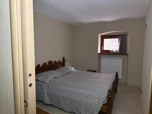 a bedroom with a bed and a window at Alloggio valle stura in Vinadio