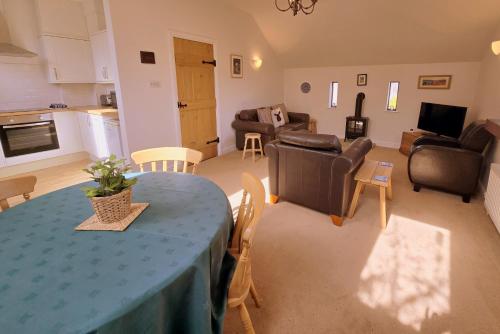 a kitchen and living room with a table and chairs at Phoenix Cottage, Bakewell in Bakewell