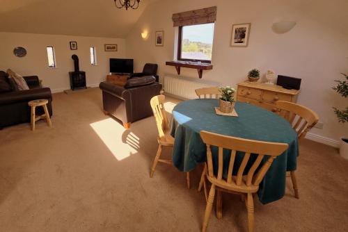 a living room with a blue table and chairs at Phoenix Cottage, Bakewell in Bakewell