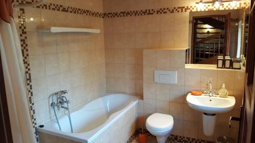 a bathroom with a tub and a toilet and a sink at Apartamenty Boszkowo in Boszkowo