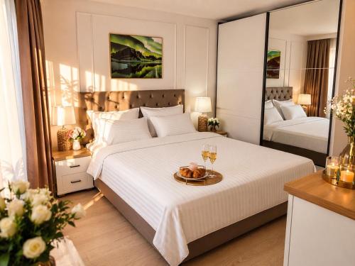 a bedroom with a bed with a tray of fruit on it at Emerald Apartment On Arena Oradea in Oradea