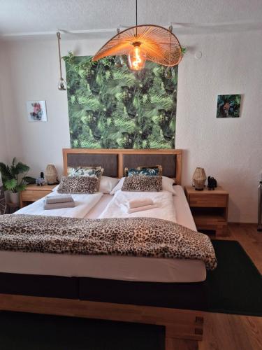 a bedroom with two beds and a large painting on the wall at Zum Blumentritt in Sankt Aegyd am Neuwalde