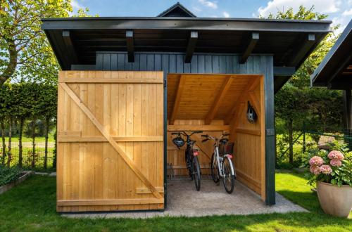 a wooden shed with two bikes in it at Apartments Poldi in Bled