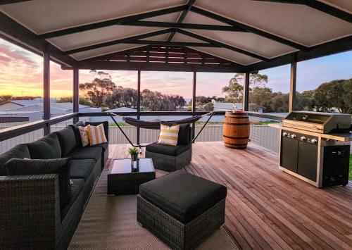 a deck with couches and a grill on a house at Seascape Cottage on Kangaroo Island in Baudin Beach