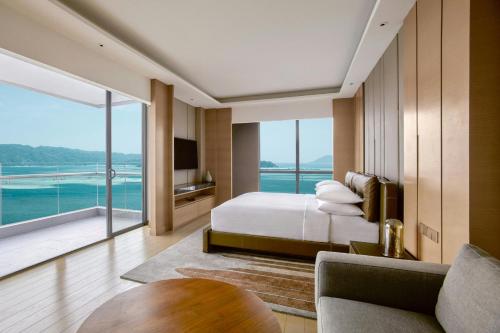 a bedroom with a bed and a large window at Kota Kinabalu Marriott Hotel in Kota Kinabalu