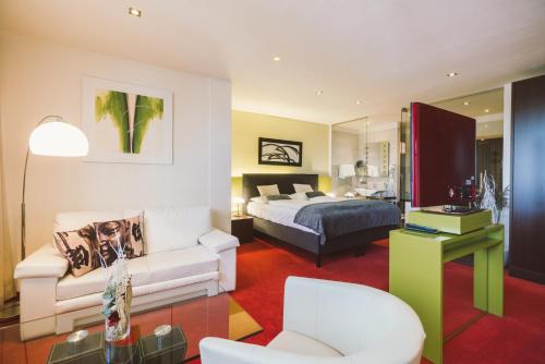 a hotel room with a bed and a couch at Hotel Restaurant Pusswald in Hartberg