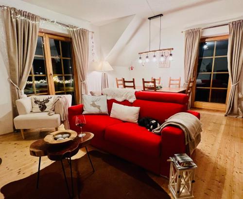a living room with a red couch and a table at Alpenliebe in Bad Kleinkirchheim
