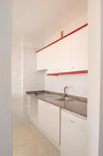 a kitchen with white cabinets and a sink at Villa De Adeje Beach in Adeje