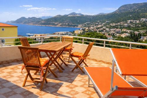 a wooden table and chairs on a balcony with a view at Villa del Mare in Dobra Voda