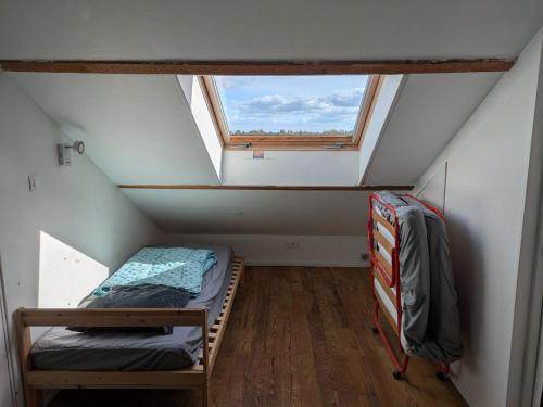 a small room with two bunk beds and a window at L'Atelier du Tailleur à 5 mn du Puy du Fou in Chambretaud