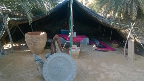 a tent with a bed and a table in the sand at Maison Proche De Désert Douz in Douz