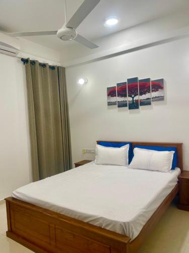 a bedroom with a large bed with two pillows at Beach Front Apartment 1 in Bopitiya