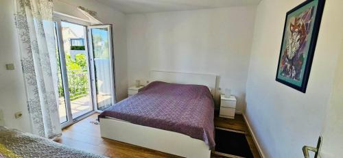 a small bedroom with a bed and a window at Apartments Porat in Porat