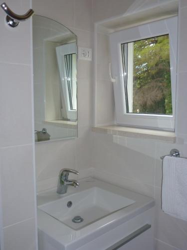 a white bathroom with a sink and a mirror at Villa Fede in Mlini