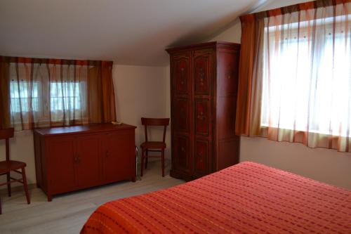 
a bedroom with a bed and a dresser at La Maga del Lago in Scanno
