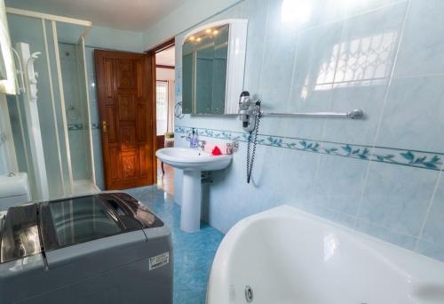 a bathroom with a toilet and a sink and a tub at Villa Bel Age Seychelles in Anse Royale